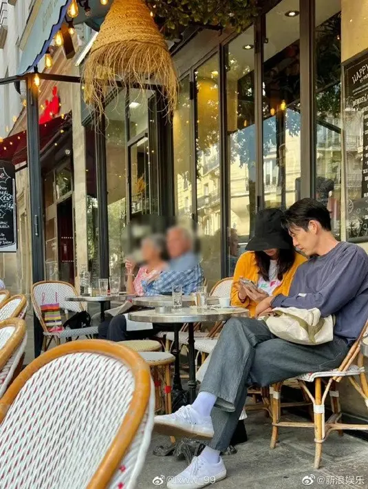 Shin Min Ah dan Kim Woo Bin asyik membicarakan sesuatu di dalam ponsel mereka. (Foto: @ixww99 on Weibo via Allkpop)
