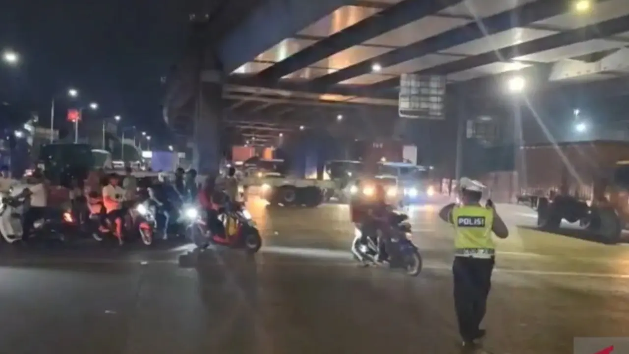 Petugas Satlantas Polres Metro Jakarta Utara mengurai kemacetan yang terjadi di kawasan Pos 9 Pelabuhan Tanjung Priok, Jakarta Utara pada Senin malam (25/5/2026).