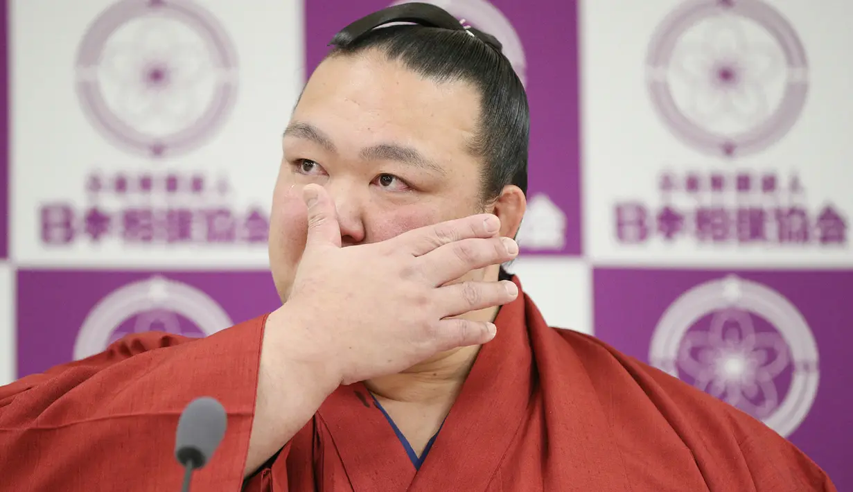 Pemegang predikat grand champion sumo, Kisenosato menyeka air matanya saat mengumumkan pensiun dari arena sumo dalam konferensi pers di Tokyo, Rabu (16/1). Kisenosato merupakan satu-satunya pesumo Jepang di liga teratas olahraga itu. (JIJI PRESS AFP)