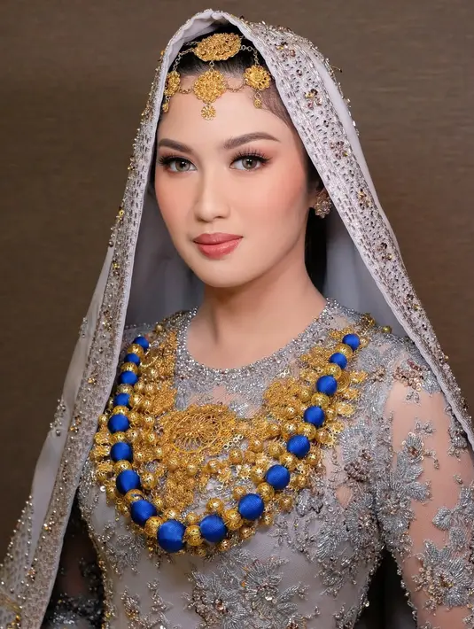 Disempurnakan dengan pulasan makeup soft glam yang flawless oleh MUA kenamaan, @marlenehariman, dan tatanan rambut oleh  @detaazhari. Kombinasi dari semua elemen ini menghasilkan tampilan yang sempurna, membuat Ochi tampil sebagai pengantin yang memancarkan pesona budaya dan keanggunan.  [@renzilazuardi/@marlenehariman].