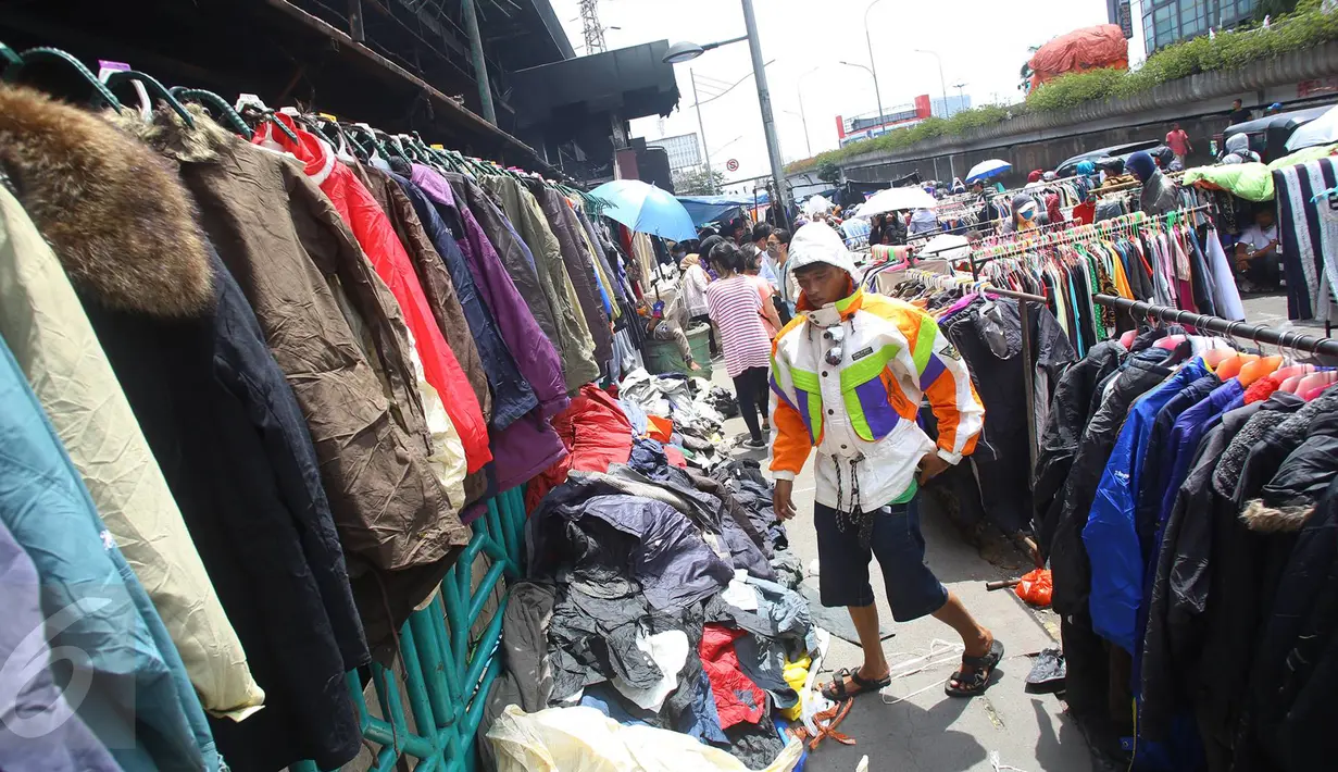 Pembeli melihat barang dagangan di kawasan Pasar Senen, Jakarta, Senin (23/1). Pascakebakaran beberapa hari lalu, para pedagang terpaksa berjualan di luar gedung, meskipun menutup jalan dan mengganggu arus lalu lintas. (Liputan6.com/Immanuel Antonius)