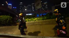 Dua robot berjalan saat menghibur pengendara di kawasan Tomang, Jakarta, Selasa (14/9/2021). Abi (20) dan Nujum (48) mengenakan kostum robot Iron Man untuk mengais rejeki dan menghibur para pengendara dari kemacetan lalu lintas yang dilakukan sejak pandemi COVID-19. (merdeka.com/Imam Buhori)