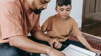 Ilustrasi Islami, muslim, mengaji, membaca Al-Qur'an. (Foto oleh Timur Weber: https://www.pexels.com/id-id/foto/pria-duduk-lantai-anak-9127731/)