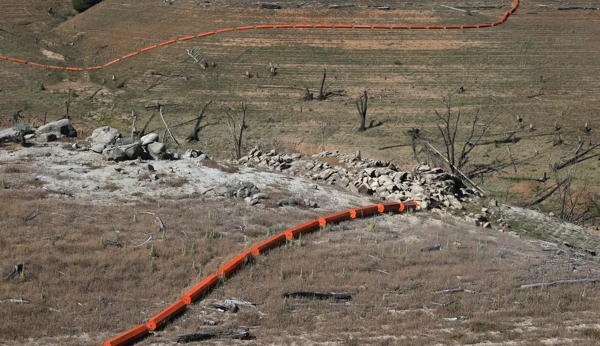 Sebuah pembatas yang dulunya terapung di atas air terlihat berada di dasar Danau Oroville yang mengering di Oroville, California (1/6/2021). Menurut Pemantau Kekeringan AS, 16 persen wilayah California telah mengalami kekeringan luar biasa. (AFP/Justin Sullivan)