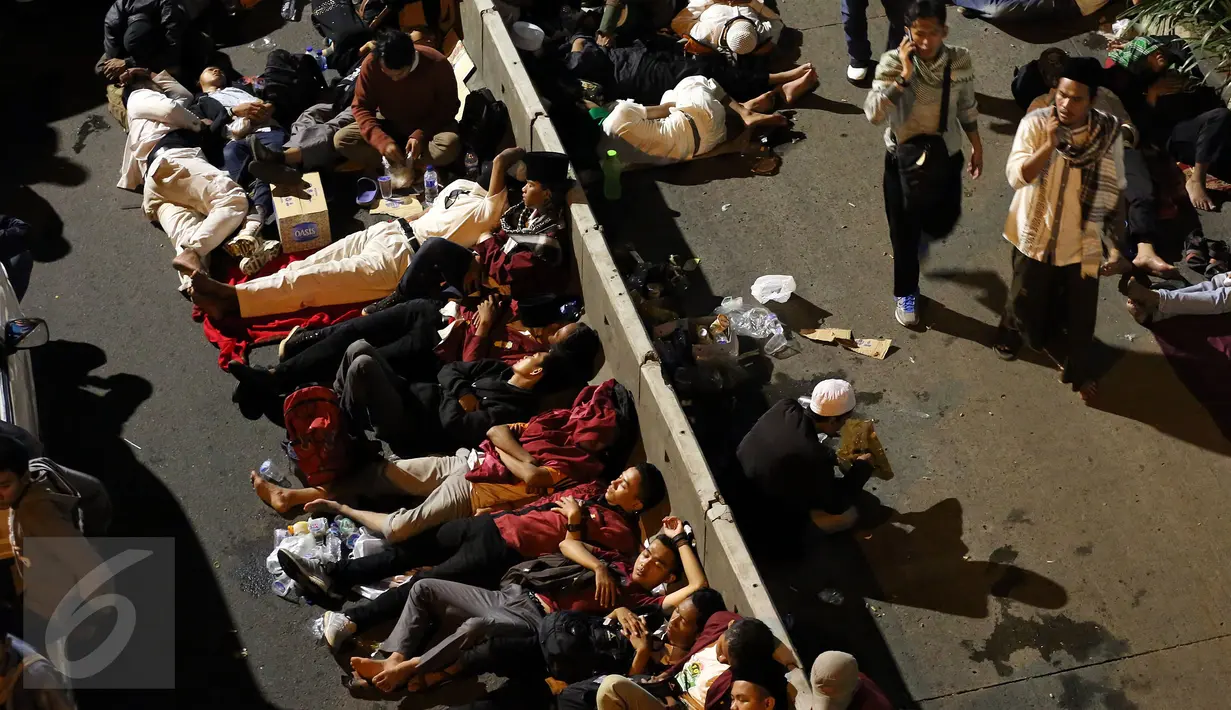 Massa peserta demo 4 November tidur di trotoar Jalan Gatot Subroto, Jakarta atau tepat di depan Gedung MPR/DPR RI, Jumat (4/11). Mereka terpaksa menginap di jalan depan Gedung DPR lantaran tak diizinkan masuk ke komplek parlemen (Liputan6.com/Johan Tallo)