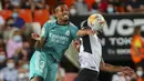 Bek Real Madrid, Eder Militao berebut bola dengan gelandang Valencia, Goncalo Guedes pada lanjutan La Liga di Stadion Mestalla, Senin (20/9/2021) dini hari WIB. Real Madrid menang 2-1 secara dramatis atas Valencia. (AP Photo/Alberto Saiz)