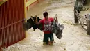 Seorang pria menyelamatkan hewan peliharaannya yang terjebak banjir di Nueva Ecija,  Filipina, Senin (19/10/2015). Topan yang memiliki kecepatan angin 175 kilometer per jam ini menciptakan gelombang ombak setinggi empat meter. (REUTERS/Erik De Castro)