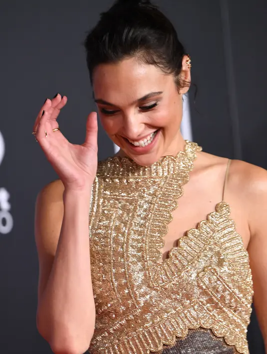 Aktris Gal Gadot tersenyum saat tiba menghadiri pemutaran perdana film produksi Warner Bros 'Justice League' di Teater Dolby di Hollywood, California, AS (13/11). Gal Gadot tampil cantik dengan gaun emas berkilauan. (AFP Photo/Robyn Beck)