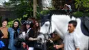 Sejumlah masyarakat menonton cabang olahraga berkuda nomor show jumping Turnamen Olahraga Selebriti Indonesia (TOSI) Season 3 yang berlangsung di Arthayasa Stable, Depok, Jawa Barat, Jumat (01/11/2024). (Bola.com/Bagaskara Lazuardi)
