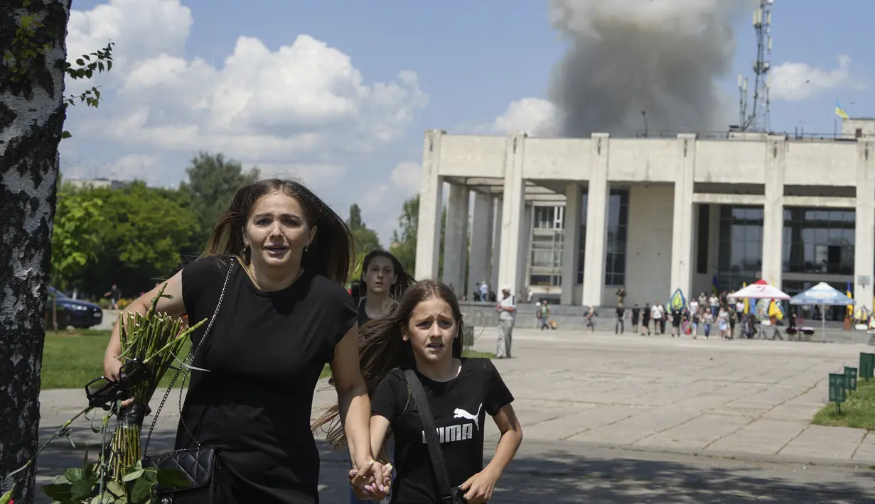 <p>Sebuah keluarga lari dari ledakan setelah serangan roket Rusia di lingkungan perumahan di Pervomaiskyi, wilayah Kharkiv, Ukraina, Selasa, 4 Juli 2023. (AP Photo/Oleksandr Magula)</p>