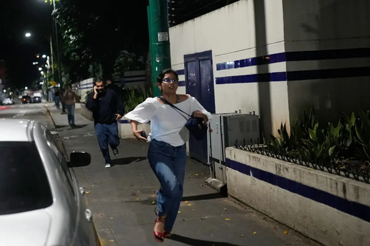 Pejalan kaki berlarian setelah ledakan dan suara pesawat terbang rendah terdengar di Caracas, Venezuela, Sabtu (3/1/2026).