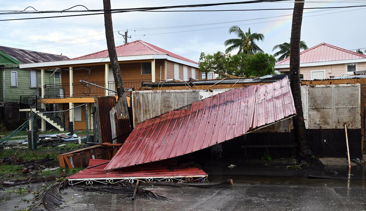 Atap sebuah rumah terlihat di jalan setelah Badai Lisa di Belize City, Belize, 3 November 2022. Badai Tropis Lisa menyebabkan banjir dan membuat sebagian negara itu menjadi gelap gulita. (Johan ORDONEZ/AFP)