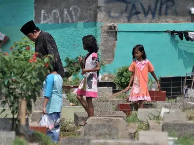 Sejumlah anak mengikuti peziarah saat menawarkan jasa membersihkan makam atau 'Ngoret' di TPU Cipinang Baru, Jakarta, Minggu (5/5). Tradisi ziarah makam atau nyekar membawa berkah rezeki bagi anak-anak yang menawarkan jasa Ngoret. (merdeka.com/Iqbal S. Nugroho)
