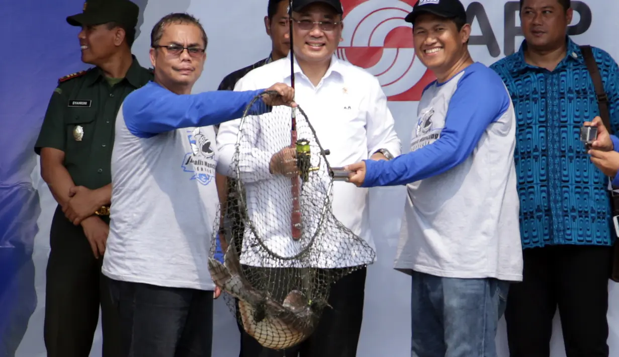 Menteri Desa, PDTT Eko Putro Sandjojo (tengah) memperlihatkan ikan patin hasil pancingannya bersama Pembina JMI Pratama D. Persadha (kanan) saat peluncuran komunitas olahraga memancing JMI di Depok, Sabtu (21/10). (Liputan6.com/Pool)