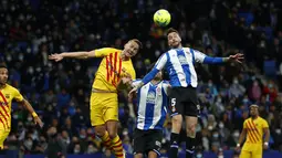 Penyerang Barcelona Luuk de Jong melompat saat berebut bola dengan bek Espanyol Fernando Calero pada jornada ke-24 Liga Spanyol 2021/22 di RCDE Stadium, Senin dini hari WIB (14/2/2022). Espanyol dan Barcelona bermain imbang 2-2. (AP Photo/Joan Monfort)