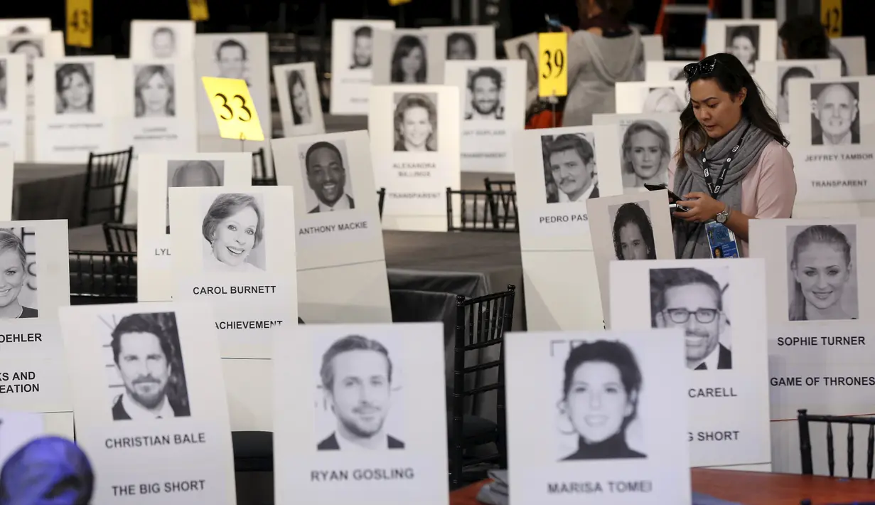 Seorang wanita berdiri diantara deretan tempat duduk  yang disertai foto para selebriti dan tamu saat persiapan jelang Screen Actors Guild Awards 2016 di Shrine Auditorium, Los Angeles, Jumat (29/1). (REUTERS/Mario Anzuoni)