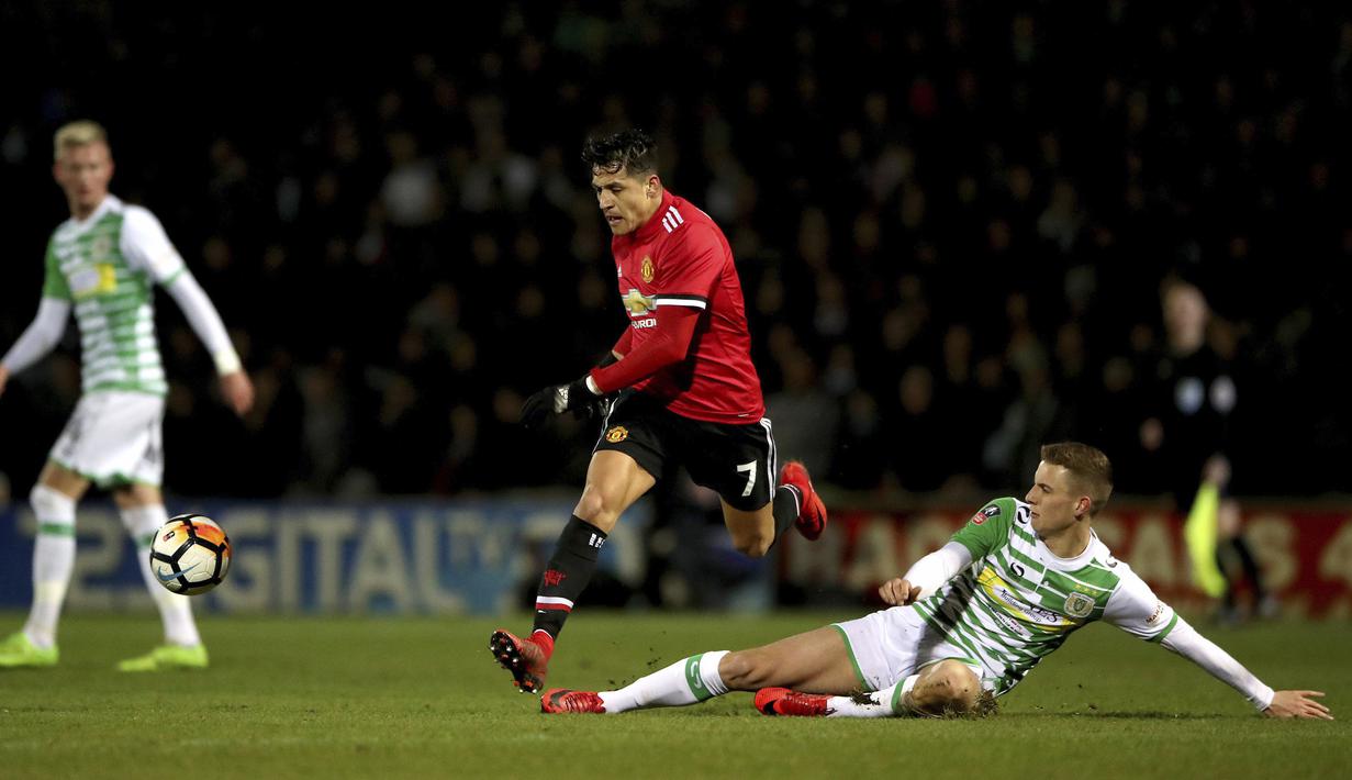 Alexis Sanchez menghindar dari terjangan pemain Yeovil Town, Lewis Wing pada babak keempat Piala FA di Huish Park, Yeovil, (26/1/ 2018). Setan Merah menang 4-0. (Nick Potts/PA via AP)