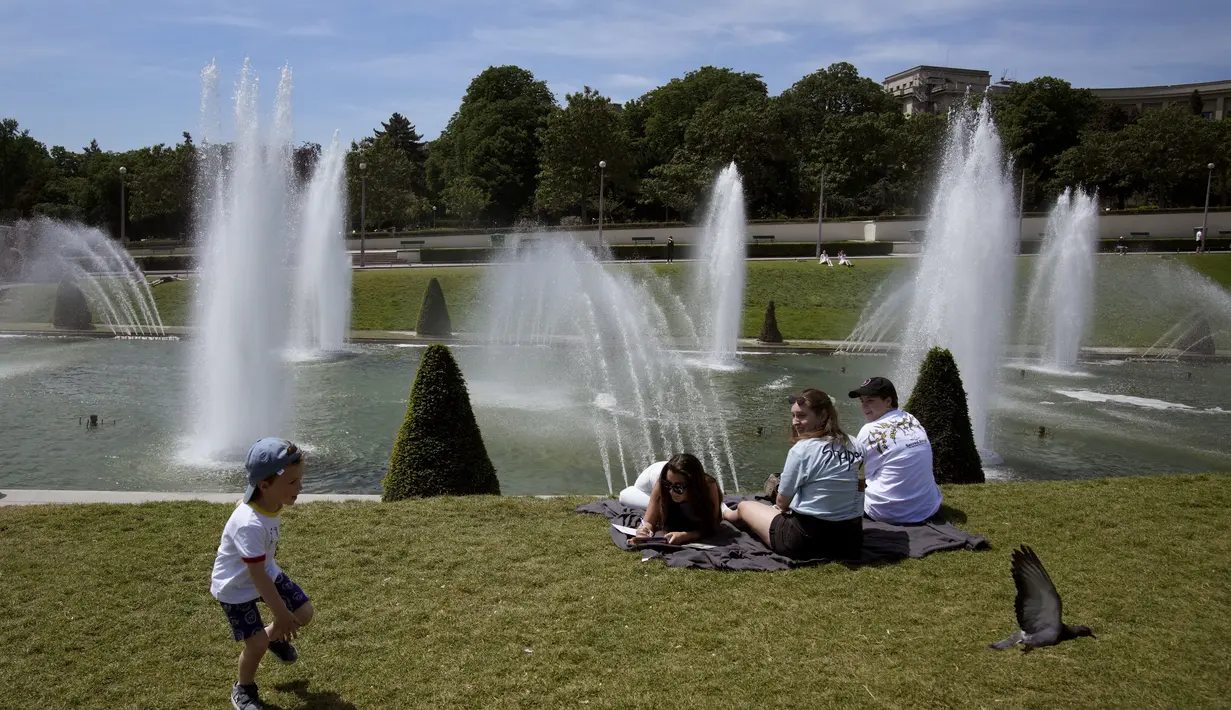 Orang-orang melakukan pendinginan di dekat air mancur taman Trocadero di Paris, Prancis, Rabu (18/5/2022). Cuaca panas diperkirakan akan berlangsung selama beberapa hari di seluruh Prancis. (AP Photo/Christophe Ena)