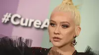 Penyanyi Christina Aguilera berpose saat tiba menghadiri 10th amfAR Gala di Los Angeles, California (11/10/2019). Aguilera tampil anggun dengan gaun hitam serta celana merah berkilau. (AP Photo/Jordan Strauss)