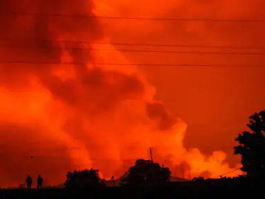 Siluet dua orang terlihat saat langit malam berubah menjadi merah akibat letusan Gunung Nyiragongo, di Goma, Kongo, Sabtu (22/5/2021). Gunung berapi Nyiragongo meletus pada Sabtu (22/5) malam memicu warga kota Goma melarikan diri menuju perbatasan dengan Rwanda. (AP Photo/Justin Kabumba)