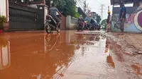 Jalan Raya Gandul Kecamatan Cinere, Kota Depok dipenuhi lumpur akibat pengeboran instalasi kabel PLN. Kondisi ini membuat jalanan menjadi licin hingga menyebabkan sejumlah pengguna jalan terjatuh. (Liputan6.com/Dicky Agung Prihanto)