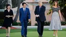 Presiden AS, Donald Trump didampingi Ibu Negara, Melania Trump berjalan bersama Perdana Menteri Jepang, Shinzo Abe dan istrinya Akie Abe untuk jamuan makan malam dalam pertemuan di Resor Mar-a-Lago, Florida, Selasa (17/4). (AP/Pablo Martinez Monsivais)