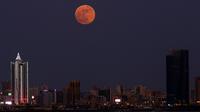 Bulan Purnama Stroberi atau Strawberry Full Moon muncul di atas Kota Kuwait, pada Kamis (24/6/2021). Strawberry Full Moon adalah istilah yang diambil dari hikayat atau cerita tradisi dari suku-suku asli Amerika. (YASSER AL-ZAYYAT / AFP)