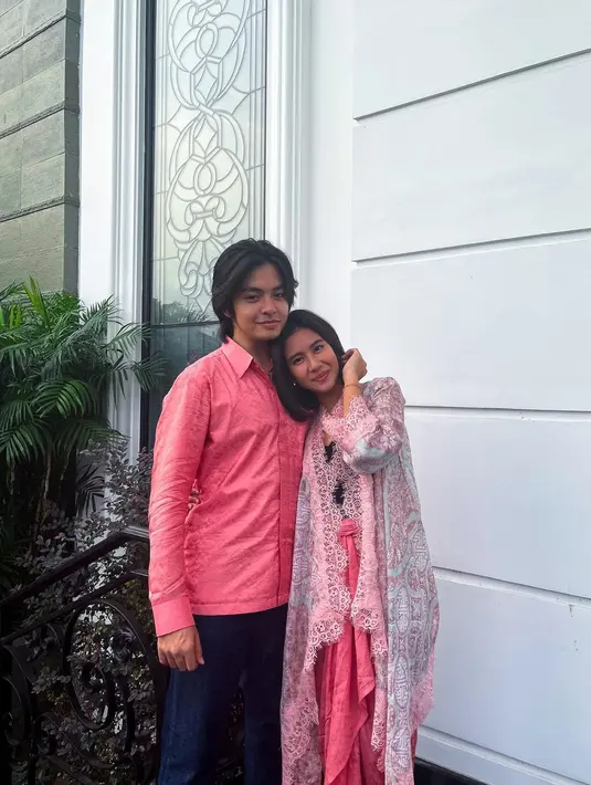 Model baju Lebaran couple Shena Cinnamon dan Angga Ayunda dengan nuansa peach. Shena memakai outerwear berpotongan kebaya viscose dan sarung lilit. (Foto: Instagram @shenacinnamon)