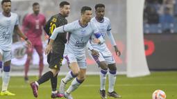 Pemain Paris Saint-Germain (PSG), Lionel Messi melihat pemain Riyadh All-Star, Cristiano Ronaldo, menggiring bola pada laga persahabatan di Stadion Raja Fahd pada Jumat (20/1/2023). Hujan gol mewarnai laga ini. PSG menang dengan skor ketat 5-4. (AP Photo/Hussein Malla)