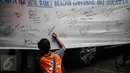 Seorang warga turut memberikan dukungan kepada Rizal Ramli sebagai bakal calon gubernur DKI 2017 dengan menandatangani spanduk, Jakarta, Senin (8/8). Aksi tersebut dilakukan oleh Konferederasi Serikat Pekerja Indonesia (KSPI). (Liputan6.com/Faizal Fanani)