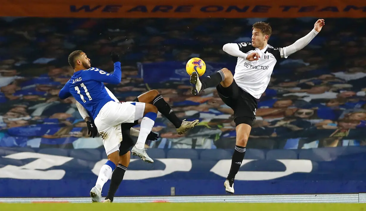 Pemain Everton Joshua King (kiri) berebut bola dengan pemain Fulham Joachim Andersen pada pertandingan Liga Inggris di Goodison Park, Liverpool, Inggris, Minggu (14/2/2021). Everton kalah 0-2 dari Fulham. (Jason Cairnduff/Pool via AP)