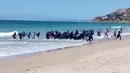 Puluhan imigran datang menggunakan perahu karet dan menyerbu pantai Cadiz di Spanyol selatan, 9 Agustus 2017. Para turis yang tengah menikmati suasana pantai dan sinar matahari di Spanyol itu mendadak terkejut. (Carlos Sanz via AP)