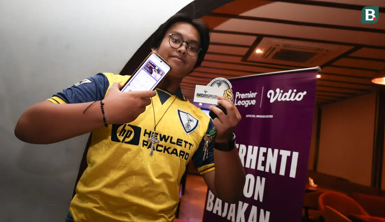 Seorang penggemar Tottenham Hotspur memperlihatkan aplikasi Youniverse yang digunakan untuk mengikuti nonton bareng Roaring Night Liga Inggris 2023/2024 antara Tottenham Hotspur kontra Arsenal di Treehaus Kemang, Minggu (28/4/2024) malam WIB yang digelar komunitas penggemar Tottenham Hotspur, IndoSpurs Jakarta. (Bola.com/Abdul Aziz)