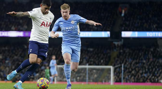 Bek Tottenham Hotspur Cristian Romero berebut bola dengan gelandang Manchester City Kevin De Bruyne pada pekan ke-26 Liga Inggris di Etihad stadium, Minggu (20/2/2022) dinihari WIB. Manchester City takluk 2-3 dari tim tamu, Tottenham Hotspur.  (AP Photo/Jon Super)