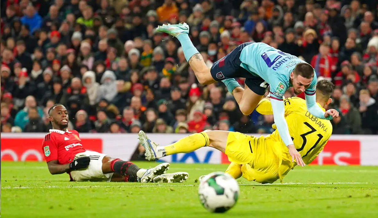 <p>Pemain Burnley Darko Churlinov bertabrakan dengan kiper Manchester United Martin Dubravka pada pertandingan sepak bola putaran keempat Piala Liga Inggris di Old Trafford, Manchester, Inggris, 21 Desember 2022. (AP Photo/Dave Thompson)</p>