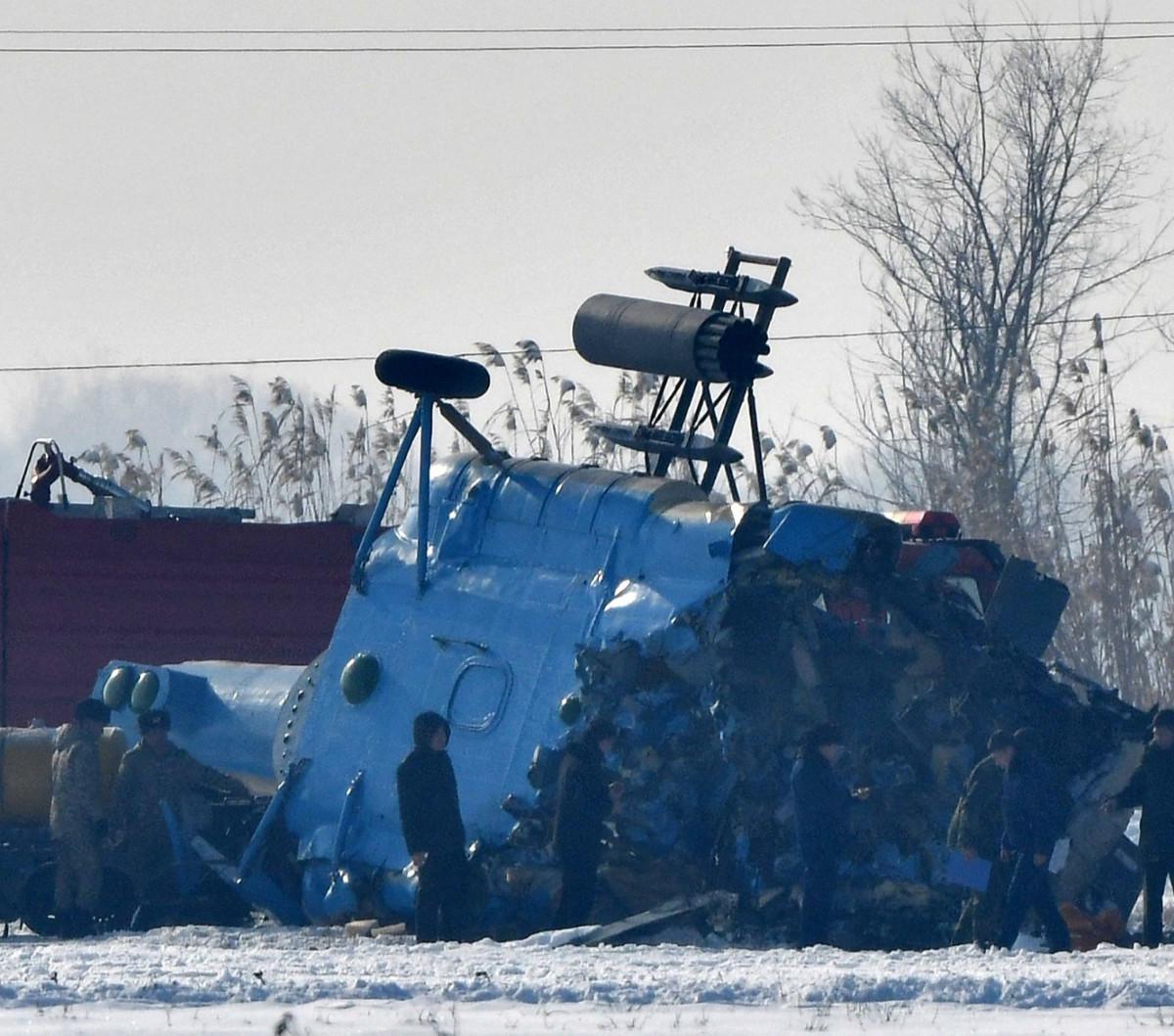 Petugas melakukan pemeriksaan puing-puing helikopter militer Kyrgyzstan Mi-8-MTV setelah jatuh di pinggiran Bishkek pada Rabu 17 Januari 2024. <br>
