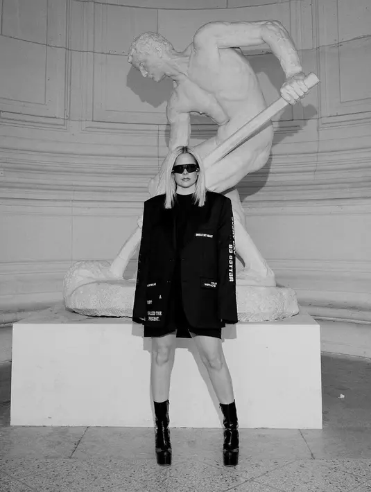 Ia mengenakan shirt dress dan structure long blazer serta platform boots [@avrillavigne]