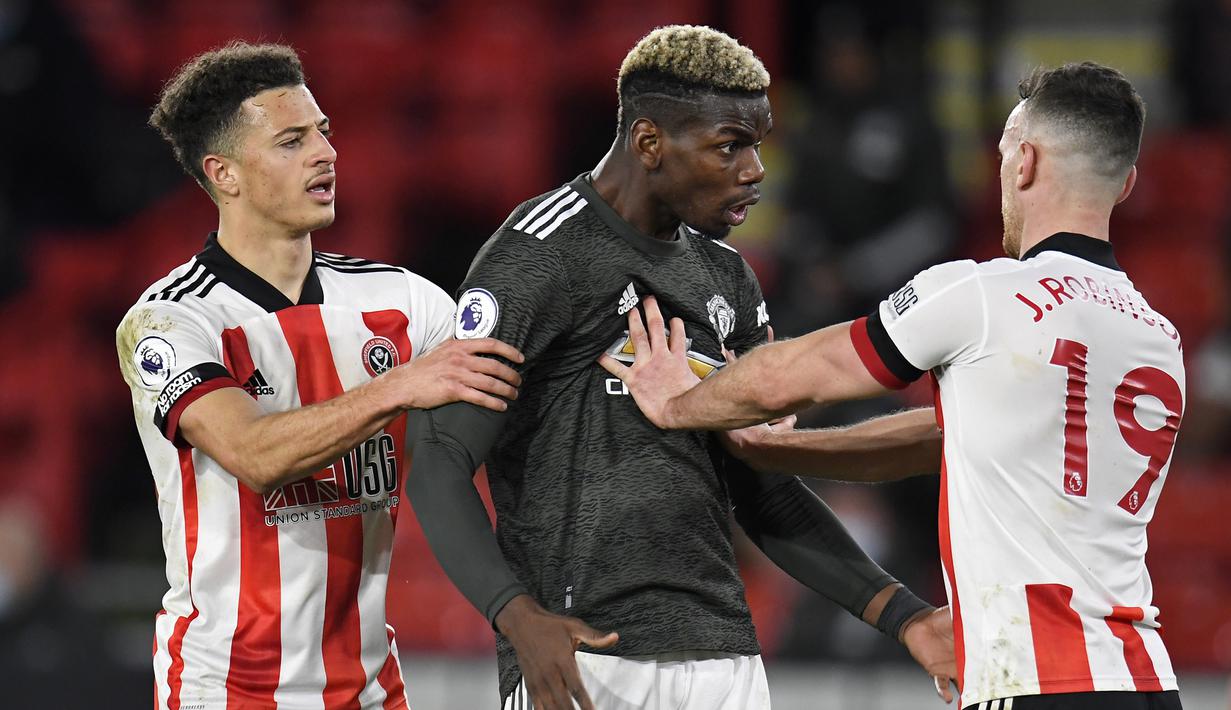 Gelandang manchester United, Paul Pogba (tengah) terlibat pertikaian dengan bek Sheffield United, Jack Robinson (kanan), dalam laga lanjutan Liga Inggris pekan ke-13 di Bramall Lane, Sheffield, Kamis (17/12/2020). Manchester United menang 3-2 atas Sheffield United. (AFP/Peter Powell/Pool)