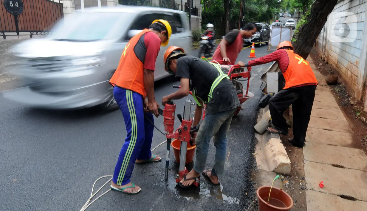 Pekerja mengebor aspal yang menutup sumur resapan di Jalan Lebak Bulus III, Cilandak, Jakarta Selatan, Senin (6/12/2021). Sebanyak 29 sumur resapan yang tertutup aspal kembali dilubangi agar bisa bisa menampung air saat curah hujan tinggi. (merdeka.com/Arie Basuki)