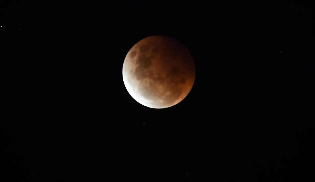 Bulan purnama terlihat selama gerhana sebagian di Sydney, Australia pada Rabu (26/5/2021). Gerhana bulan total yang bertepatan dengan Supermoon untuk pertama kalinya dalam dua tahun. (Saeed KHAN / AFP)