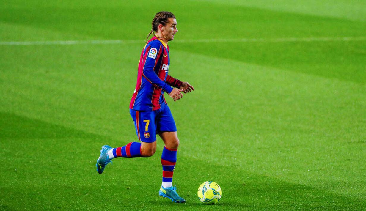 Penyerang Barcelona, Antoine Griezmann, menggiring bola saat melawan Real Sociedad pada laga Liga Spanyol di Stadion Camp Nou, Kamis (17/12/2020). Barcelona menang dengan skor 2-1. (AP/Joan Monfort)