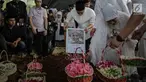 Anak Hatta Rajasa, Rasyid Rajasa meletakan foto almarhum istrinya Adara Taista di makam TPU Tanah Kusir, Jakarta, Senin (21/5). Kabarnya, Adara Taista meninggal dunia karena menderita sakit kanker kulit. (Liputan6.com/Faizal Fanani)