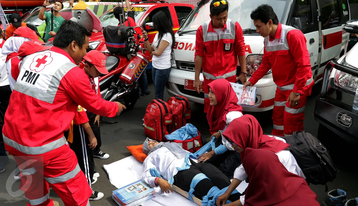 Petugas memberitahu cara menyelamatkan korban menggunakan tandu di acara Madrasah Siaga Bencana di hari bebas kendaraan bermotor di kawasan Thamrin, Jakarta, Minggu (22/1). (Liputan6.com/Johan Tallo)