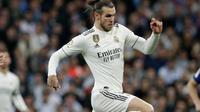 Gelandang Real Madrid, Gareth Bale berusaha melewati gelandang Barcelona, Gerard Pique selama pertandingan lanjutan La Liga Spanyol di stadion Santiago Bernabeu, Madrid (2/3). Barcelona menang tipis atas Real Madrid 1-0. (AP Photo/Andrea Comas)