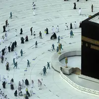 Pekerja melakukan disinfeksi untuk membantu mengekang penyebaran virus corona COVID-19 saat jemaah umrah tawaf mengelilingi Ka'bah pada awal bulan suci Ramadhan di Masjidil Haram, Mekkah, Arab Saudi, Senin (12/4/2021). (AP Photo/Amr Nabil)