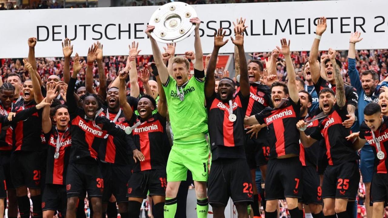 Kiper Bayer Leverkusen,&nbsp;Lukas Hradecky mengangkat trofi juara Bundesliga 2023/2024 di&nbsp;Stadion BayArena, Leverkusen, Jerman, Sabtu (18/5/2024) malam WIB. Kesuksesan Bayer Leverkusen menjuarai Bundesliga ini semakin sepektakuler setelah menutup mu