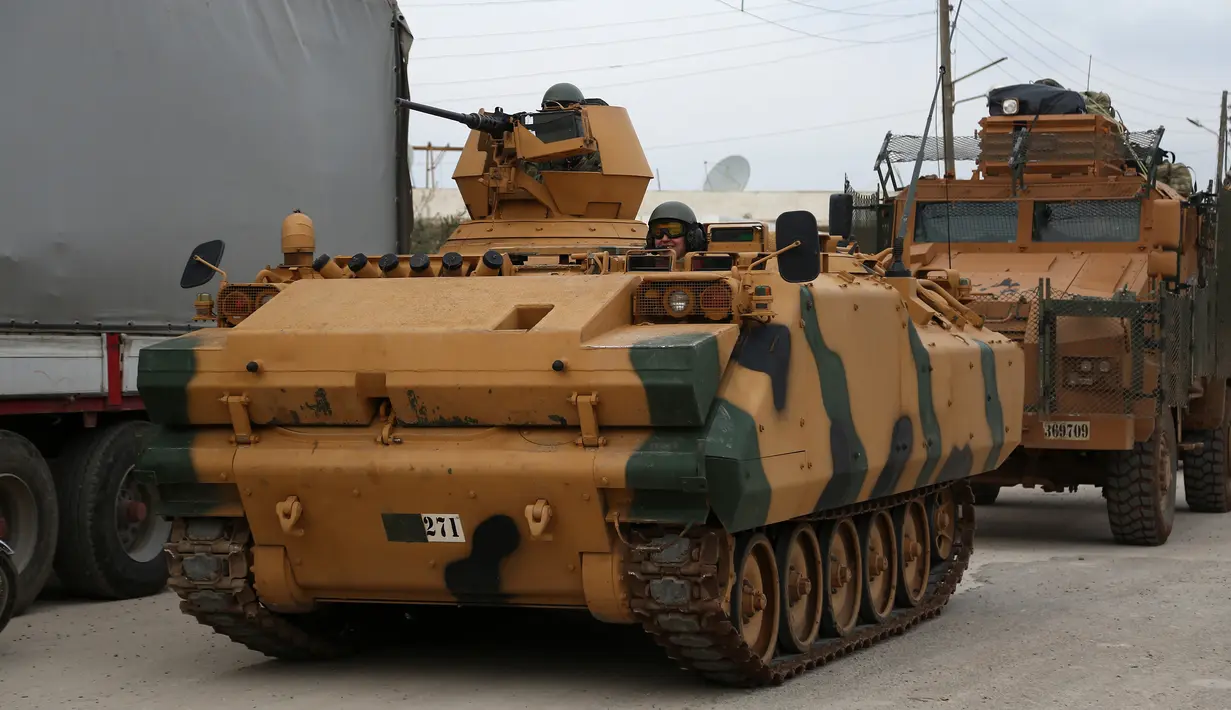 Pasukan lapis baja Turki (APC) melintasi persimpangan perbatasan Bab al-Salamah antara Suriah dan Turki di utara provinsi Aleppo (21/1). (AFP/ Nazeer al-Khatib)
