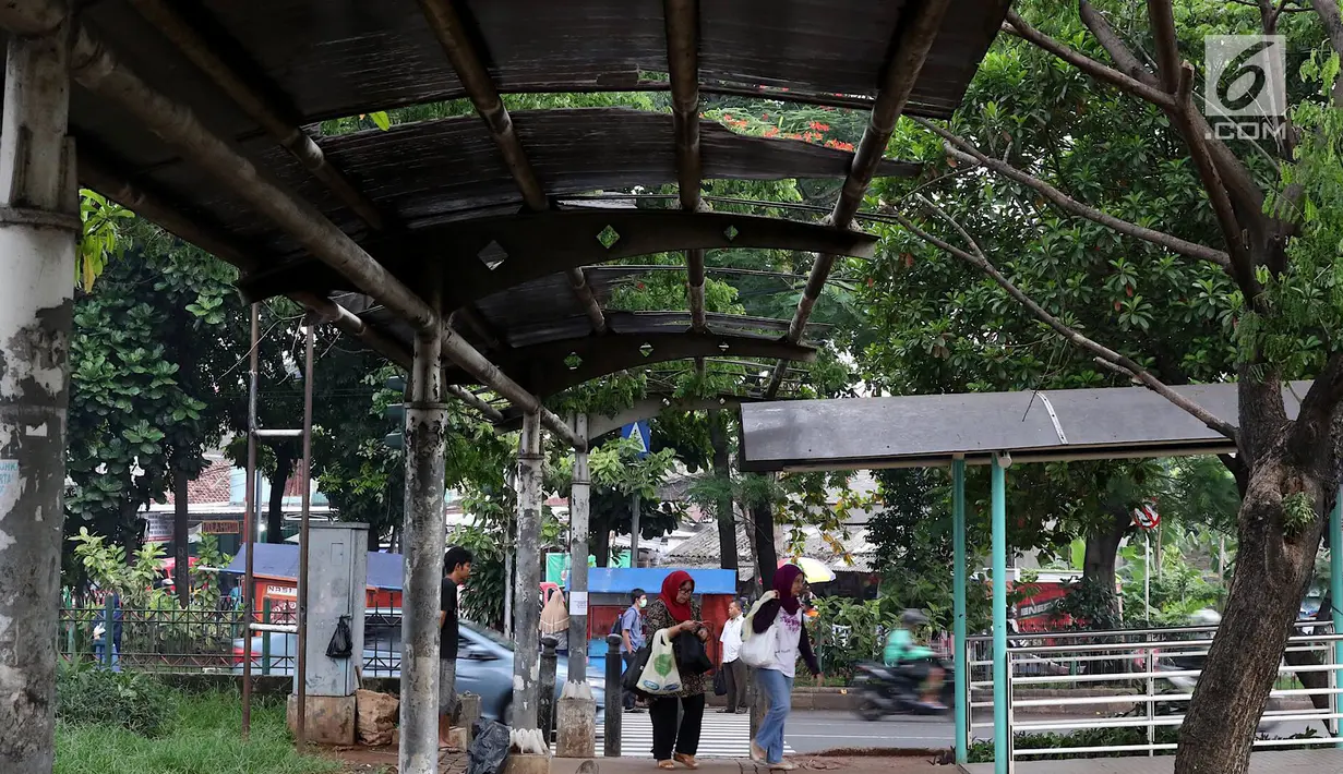 Warga melintasi jalur khusus pejalan kaki di kawasan Kampung Rambutan, Jakarta, Selasa (19/2). Atap rusak yang juga tidak dilengkapi dengan lampu penerangan mengganggu kenyamanan pejalan kaki. (Liputan6.com/Immanuel Antonius)