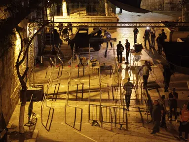 Aparat keamanan Israel membongkar detektor logam di depan pintu masuk kompleks Masjid Al Aqsa di Kota Tua Yerusalem, Selasa (25/7) dini hari. Hal itu dilakukan, setelah PM Israel Benyamin Netanyahu mengambil voting kabinet. (AP Photo/Mahmoud Illean)