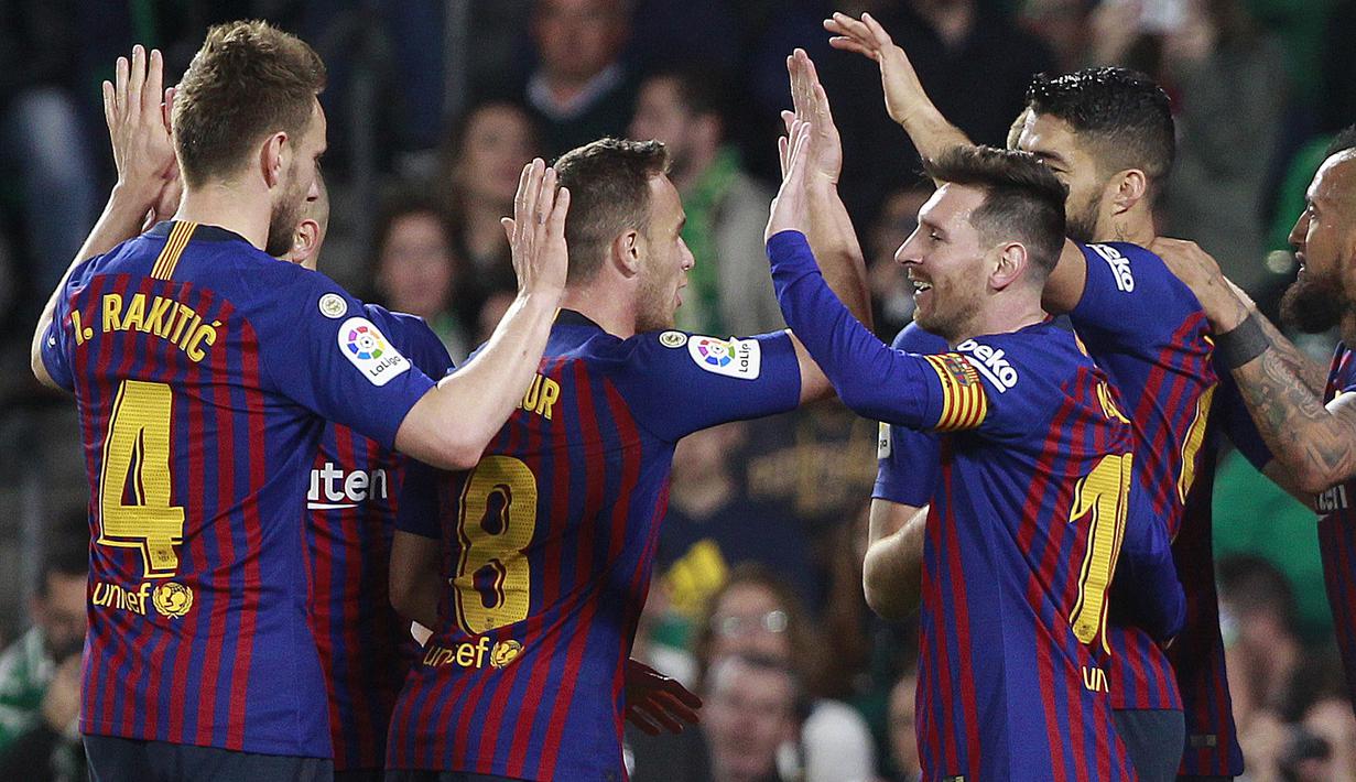 Para pemain Barcelona merayakan gol yang dicetak oleh Lionel Messi ke gawang Real Betis pada laga La Liga 2019 di Stadion Benito Villamarin, Minggu (17/3). Barcelona menang 4-1 atas Real Betis. (AP/Miguel Morenatti)